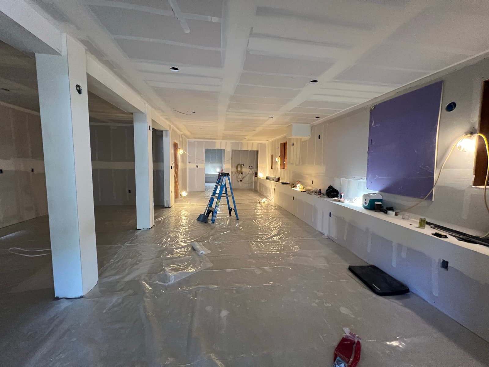 The lower level drywalled, the new ceiling height plain, the posts boxed in