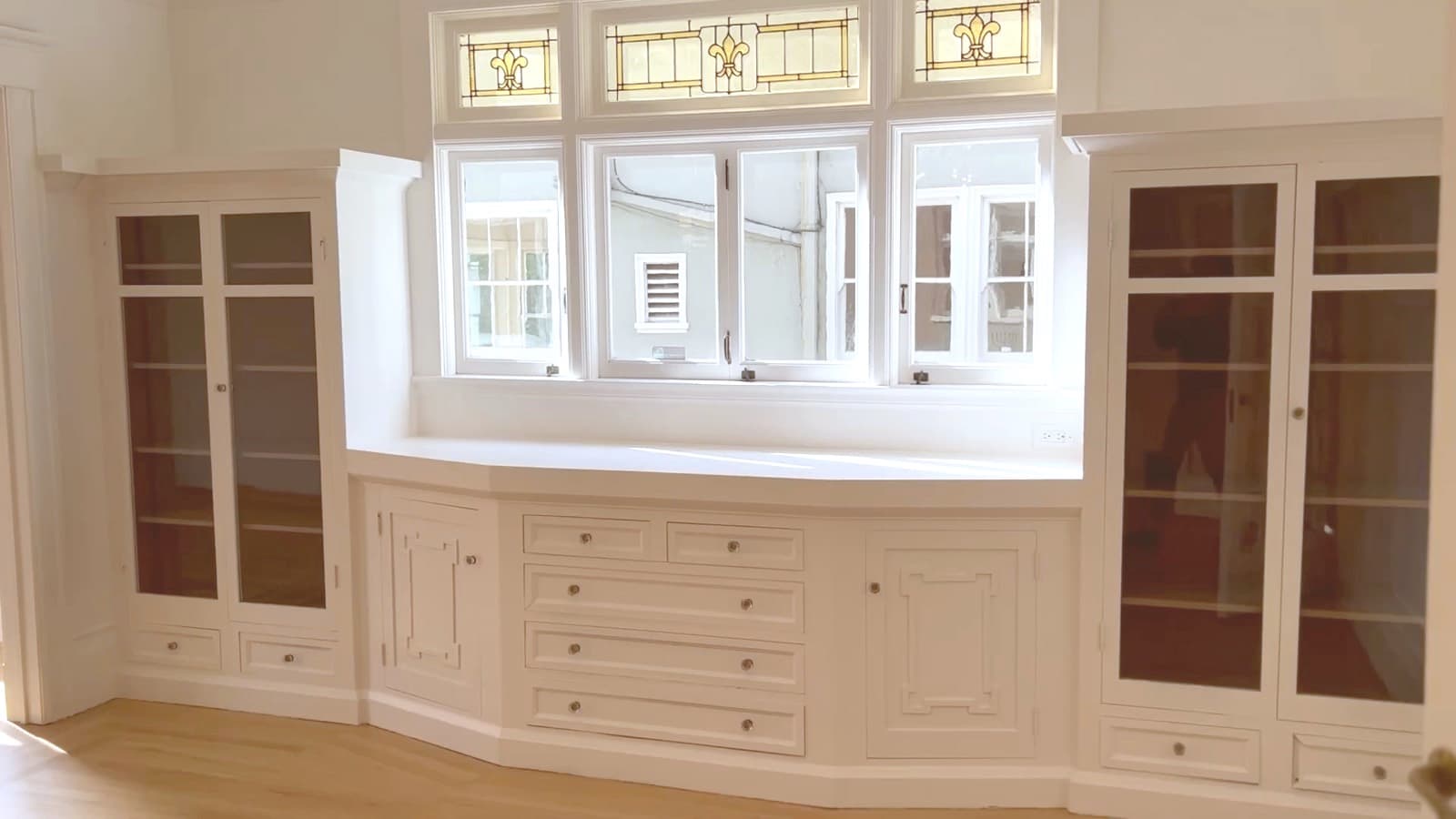 The dining room as purchased: the built-in buffet, both glass-fronted china cabinets and the stained-glass transoms, all painted white