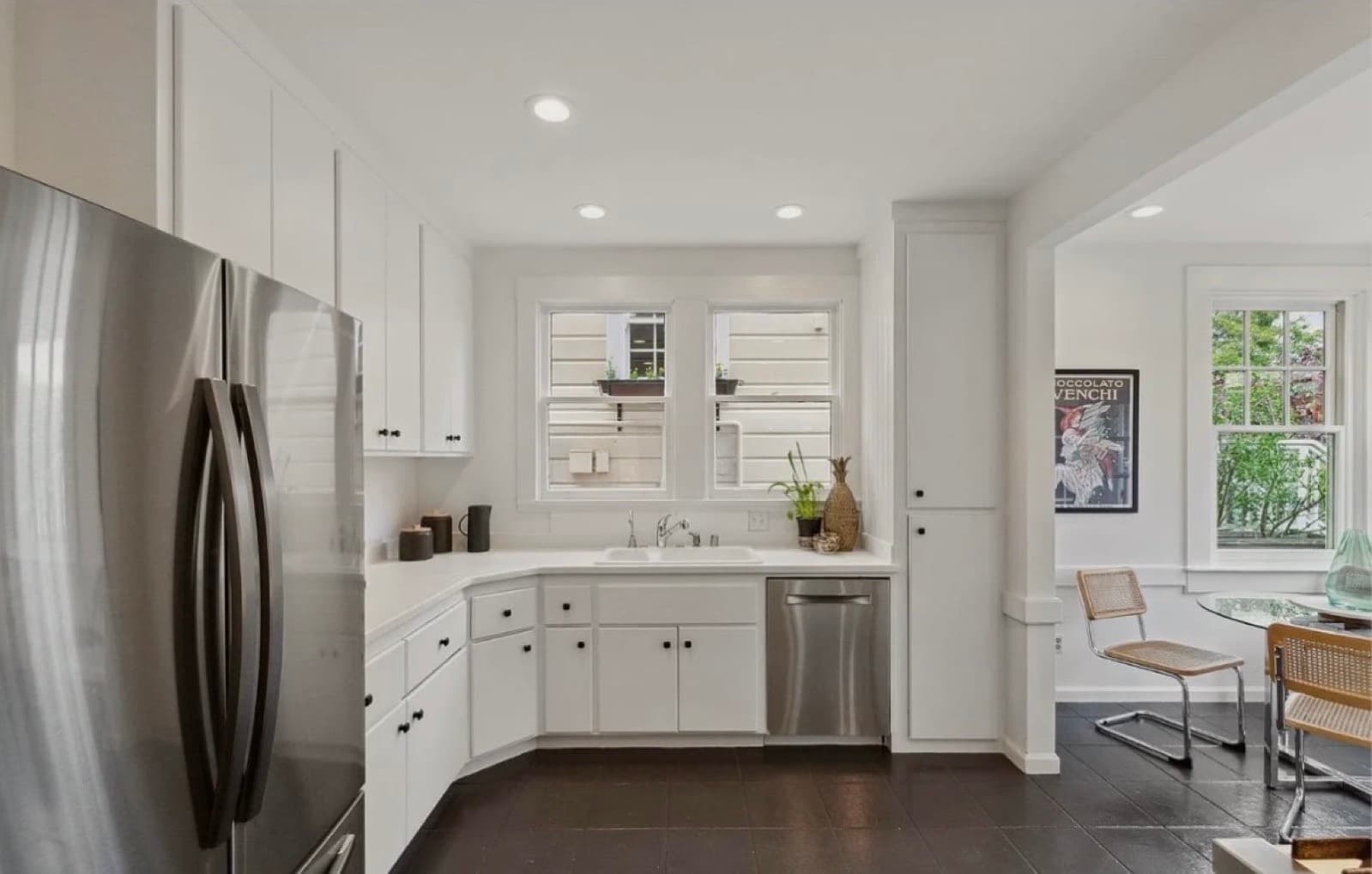 Small white kitchen with a dividing island and dark slate floor, as purchased